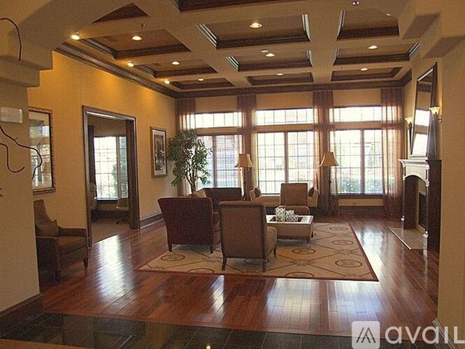 A living room with a brown sofa set and a large window.