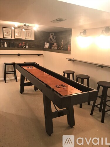 A pool table with a brown cloth and a lighted ball on it.