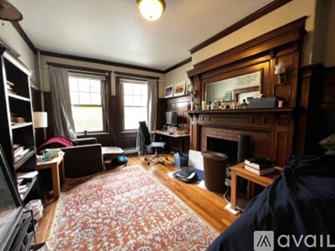 A living room with a fireplace and a rug on the floor.