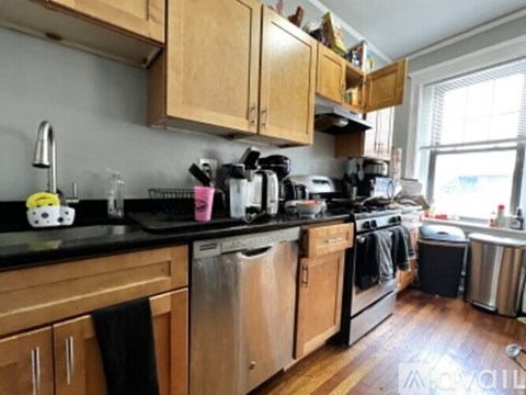 A kitchen with wooden cabinets and black countertops.