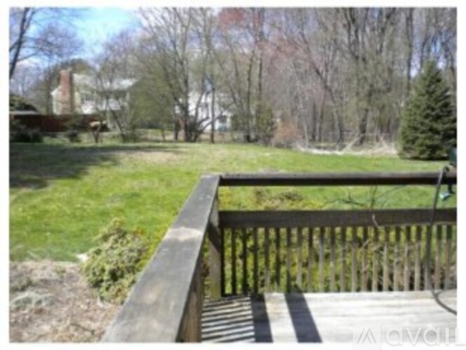 A wooden deck overlooks a grassy yard.