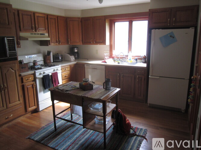 A kitchen with wooden cabinets and a white fridge.