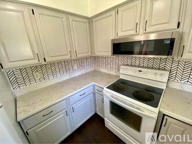 A kitchen with white cabinets and a white oven.