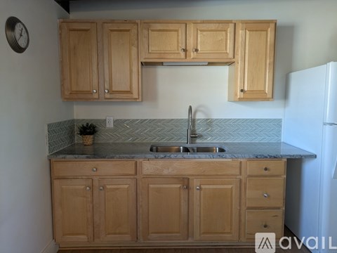 A kitchen with wooden cabinets and a marble countertop.