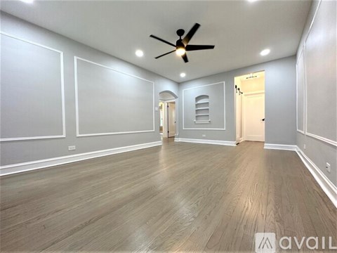 A spacious room with a ceiling fan and lighting fixtures.