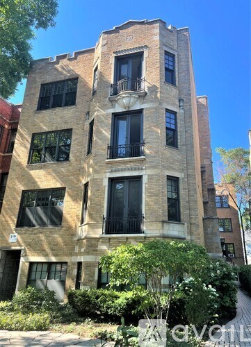A tall building with a balcony on the second floor from the front.
