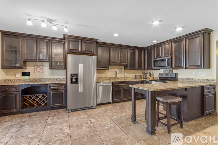 A kitchen with brown cabinets and a marble countertop.