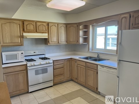 A kitchen with wooden cabinets and white appliances.