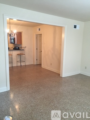A room with a bar area and a door.