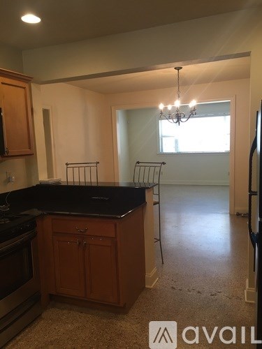 A kitchen with wooden cabinets and a black countertop.