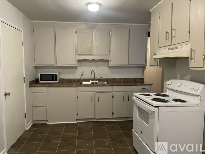 A kitchen with white cabinets and a white stove.