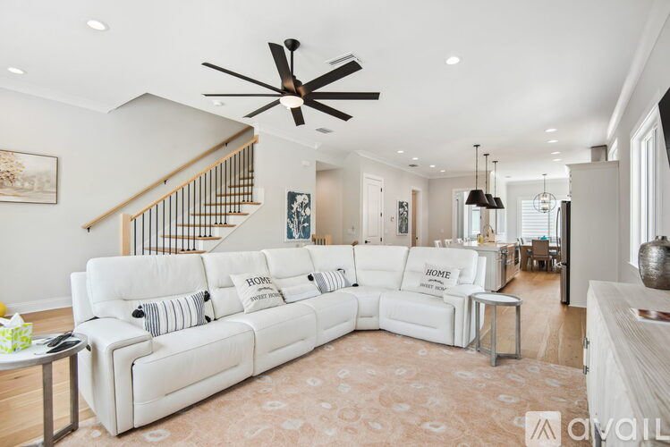 A living room with a white couch and a ceiling fan.