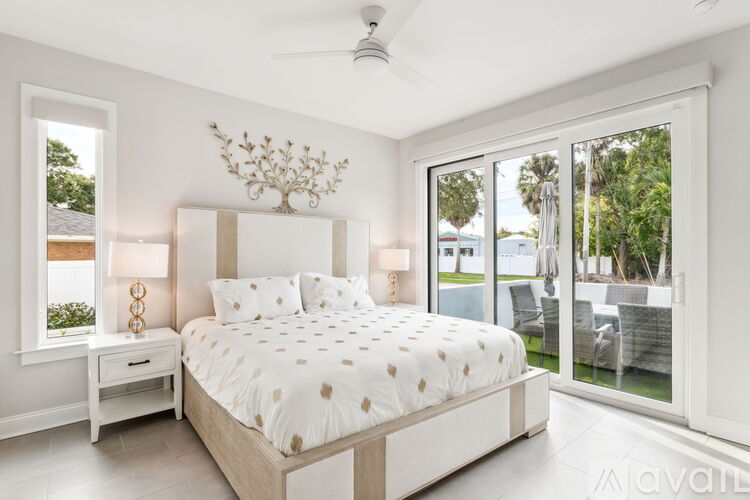 A bedroom with a large bed and a chandelier.