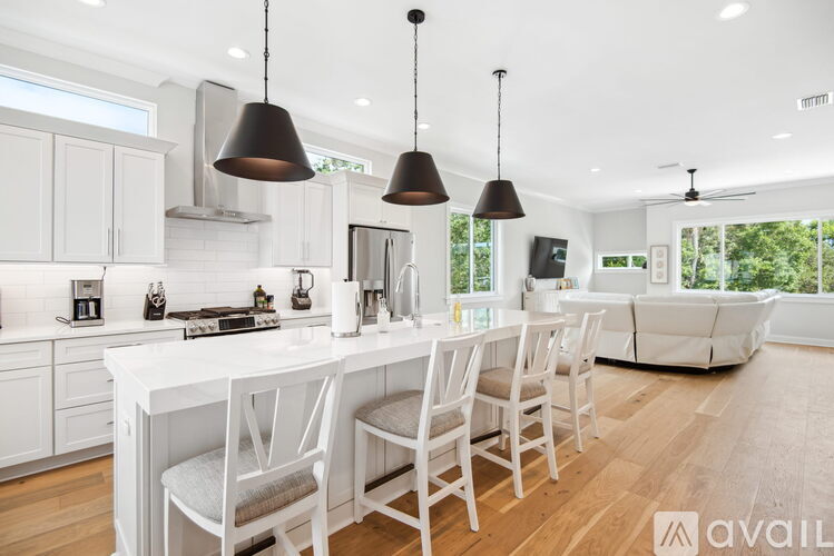 A modern kitchen with white cabinets and a large island.