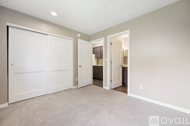 A room with two doors and one open to a kitchen.