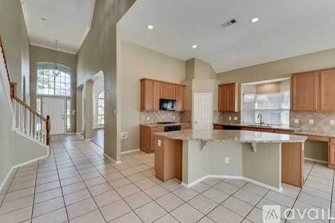 A spacious kitchen with wooden cabinets and a central island.