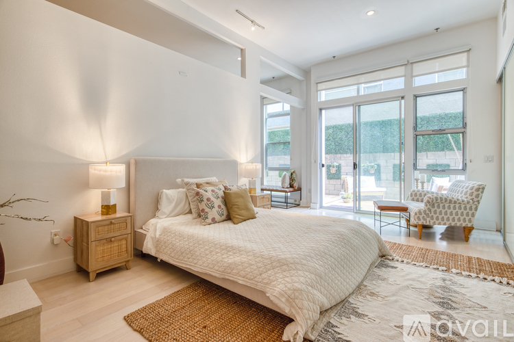 A bedroom with a large bed and a chair.