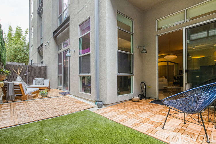 A patio with a chair and a table outside a building.