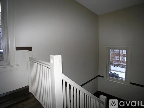 A room with a window and a white railing.