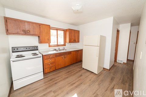 A kitchen with wooden cabinets and a white stove top oven.