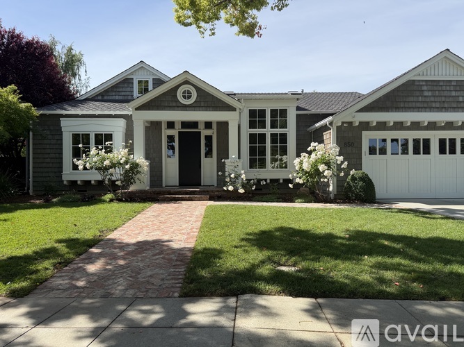 A house with a brick pathway leading to the front door.