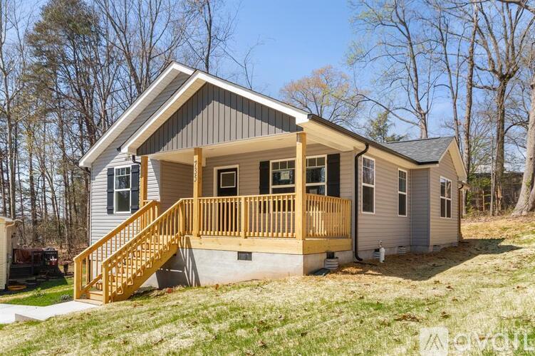A small house with a wooden deck and stairs.