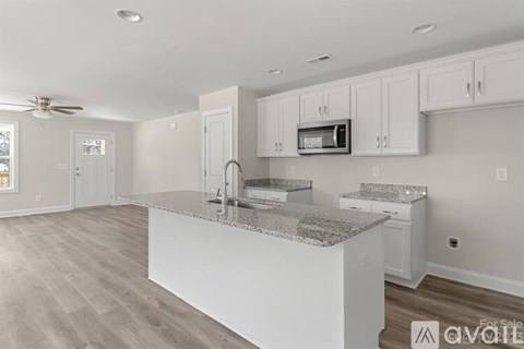 A kitchen with white cabinets and a granite countertop.