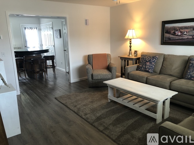 A living room with a couch, chair, and lamp.