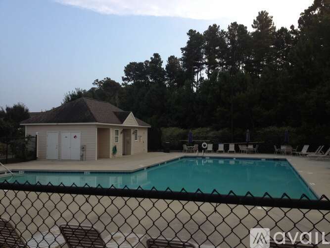 A pool with a fence in front of a house.