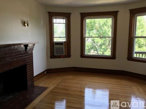 A room with a fireplace and two windows.
