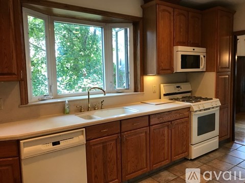 A kitchen with wooden cabinets and white appliances.