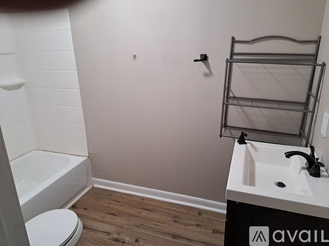 A bathroom with a toilet, sink, and a bathtub.