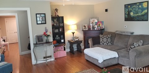 A living room with a grey couch and a white ottoman.