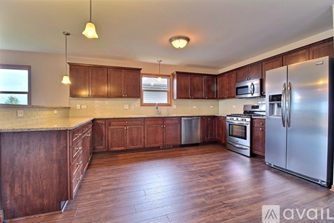 A kitchen with wooden cabinets and a refrigerator.