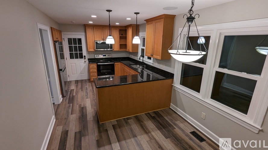 A kitchen with wooden cabinets and a black countertop.