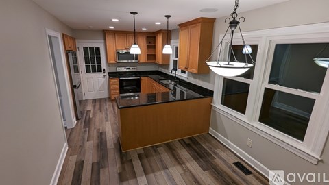 A kitchen with wooden cabinets and a black countertop.