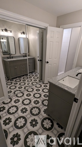 A bathroom with a patterned floor and a sink.