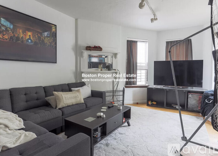 A living room with a grey couch and a television.