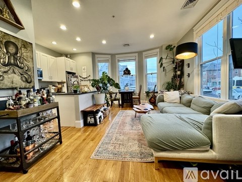 A living room with a grey couch and a wooden floor.