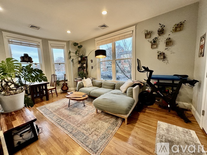 A living room with a grey couch, a coffee table, and a guitar.
