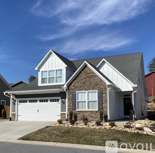 A two-story house with a garage and a covered porch.