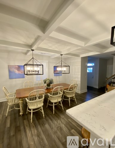 A dining room with a wooden table and chairs.