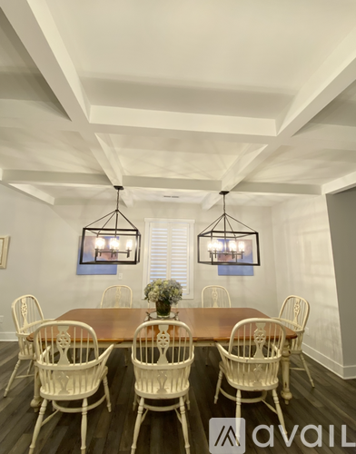 A dining room with a wooden table and chairs.