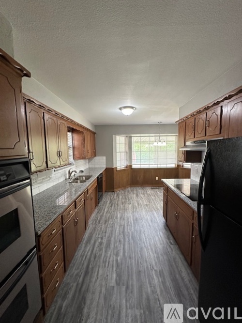 A kitchen with wooden cabinets and black appliances.