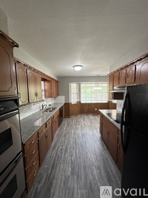 A kitchen with wooden cabinets and black appliances.