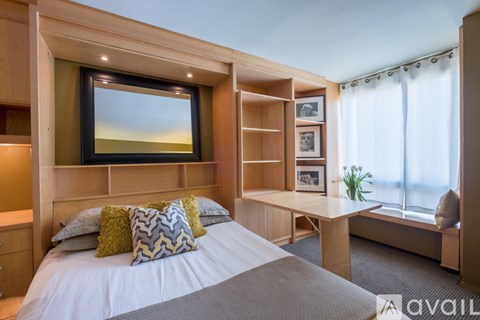 A bedroom with a large bed and a window with a view of the sky.