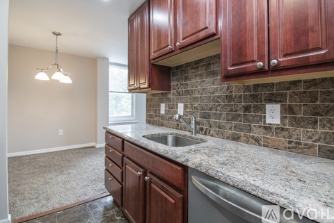 A kitchen with brown cabinets and a granite countertop.