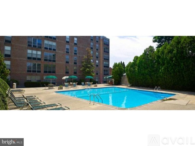 A large swimming pool surrounded by a grassy area and trees.
