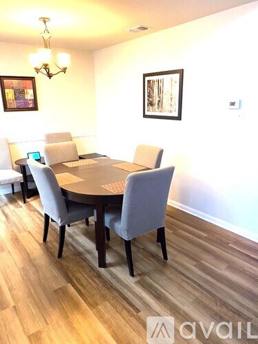 A dining room with a round table and chairs.