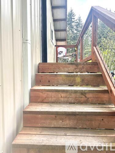 A set of wooden stairs leading up to a balcony.
